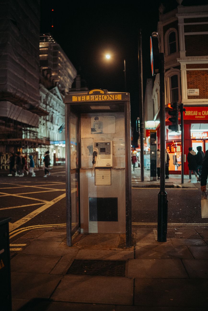 obsolete public telephone booth in city at night