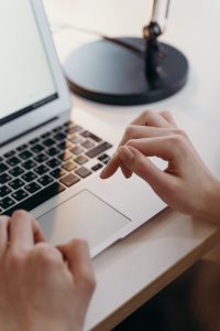 high angle shot of a person s hands typing on a laptop
