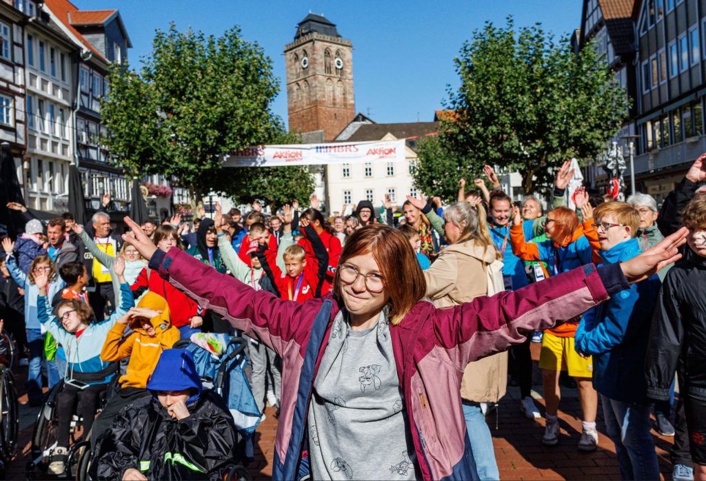 Gruppenbild von vielen glücklichen Teilnehmern mit und ohne Behinderung bei einem Tag mit dem Inklusionsmobil.